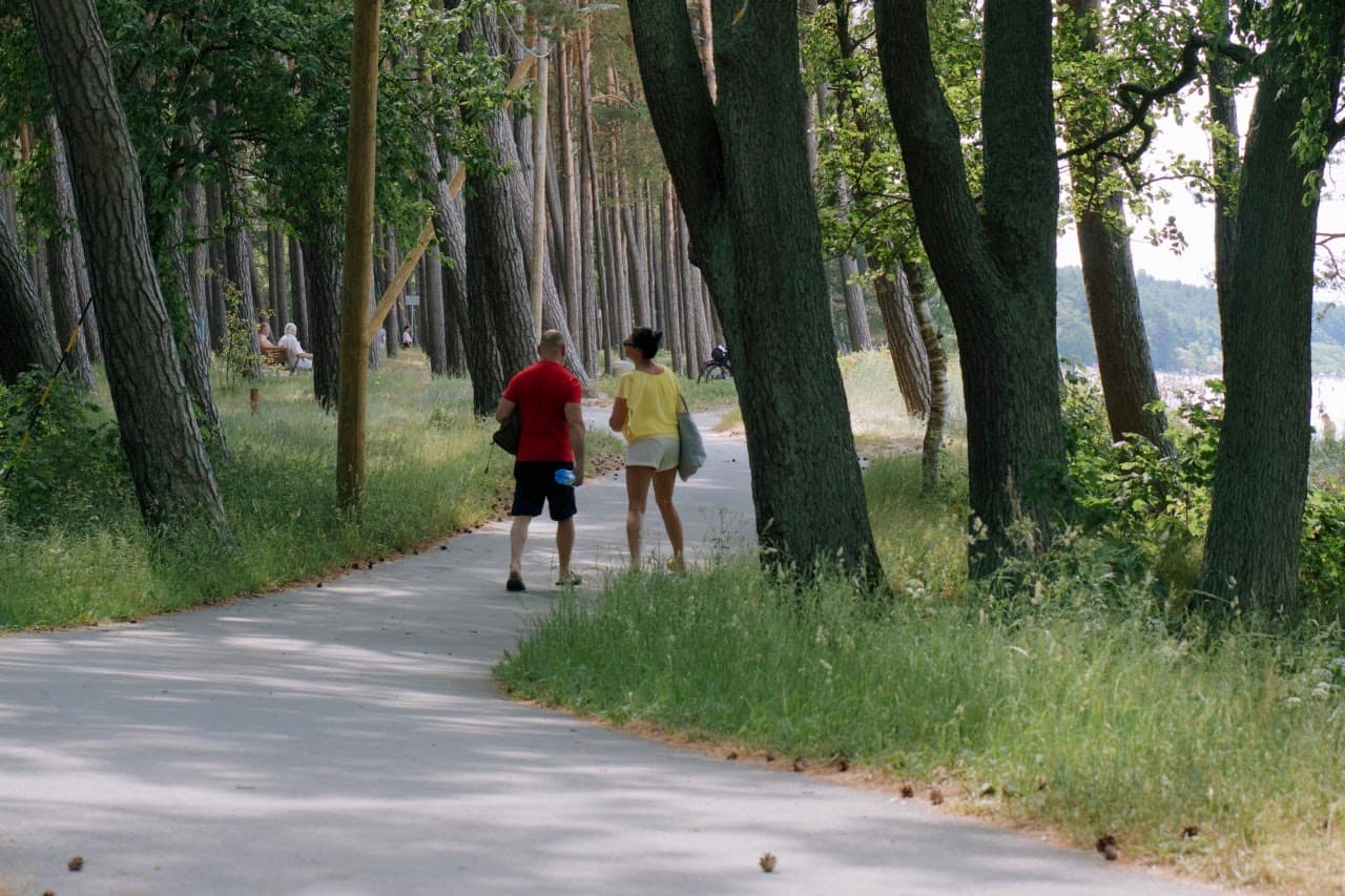 People are walking and sitting in the park at Pirita beach, Tallinn.